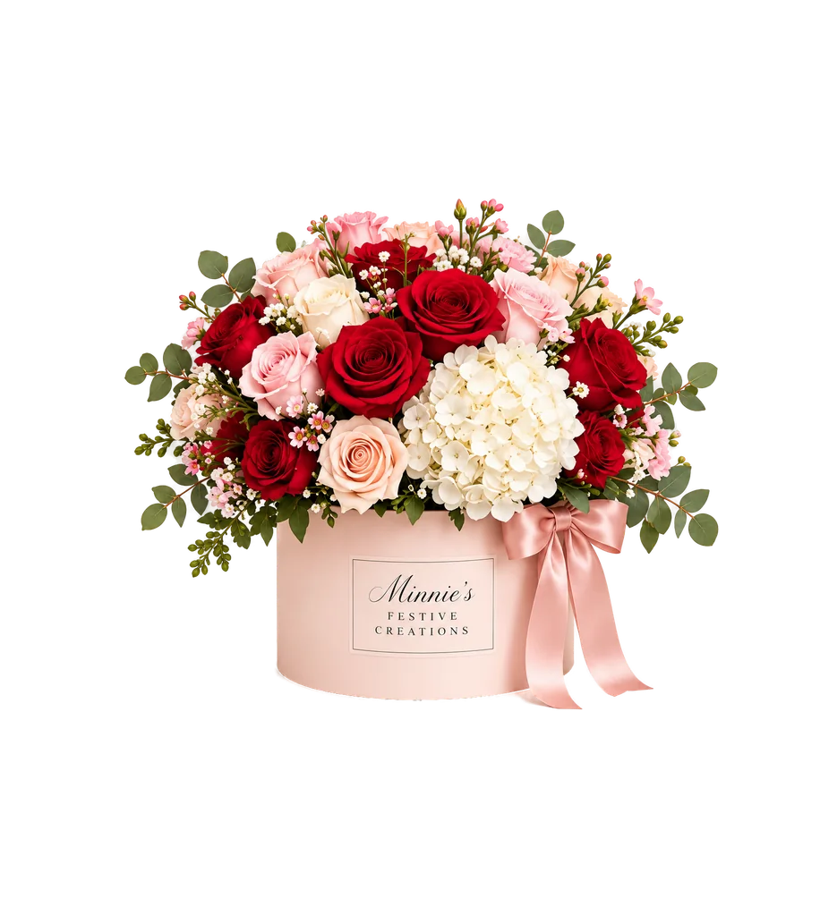 Deluxe arrangement of red and pink roses with white hydrangea in a round blush box