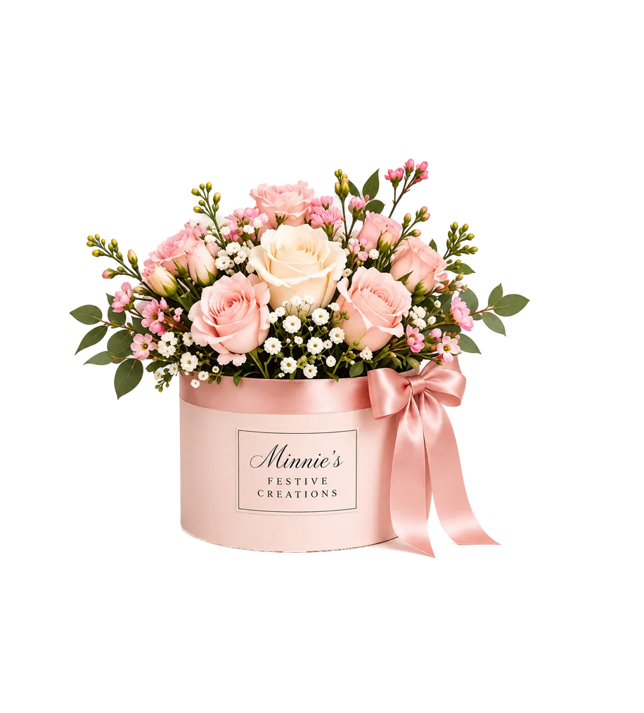 Petite arrangement of pink and cream roses with wax flower in a round blush box